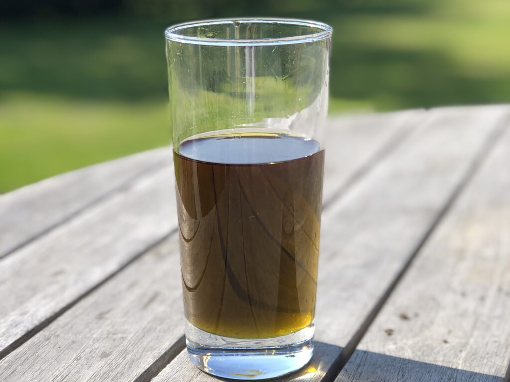 Olivgrön pepparmyntsolja i glas.